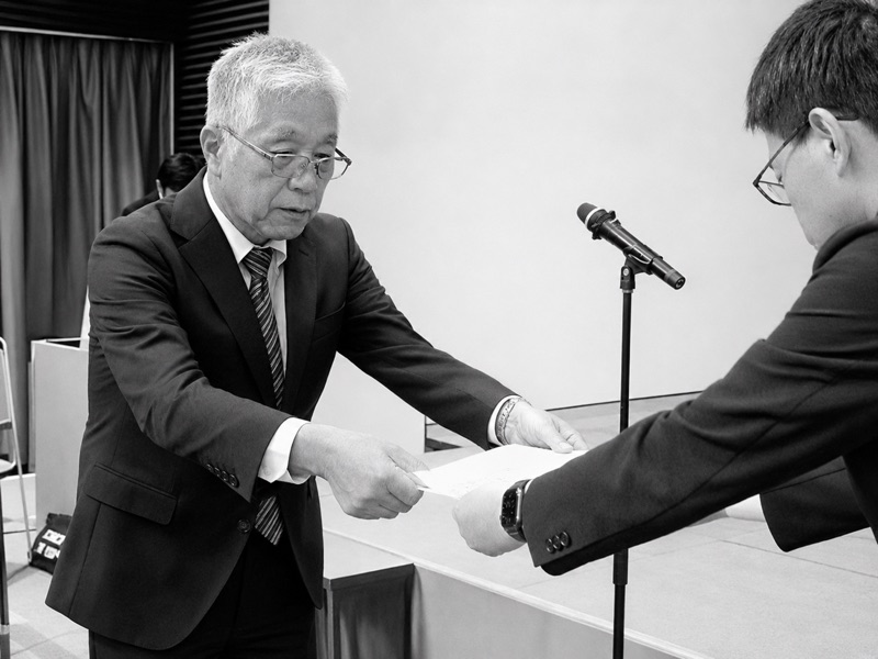 富士鷹岡地区防犯協力会の稲葉健次会長が富士市長へ防犯資機材の目録を手渡す様子